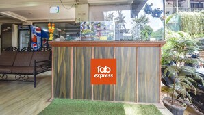 A reception desk with a 'fab express' sign, a Pepsi vending machine, and a seating area with a brown sofa. - Via Tasty Buds - 300m From Calangute Beach (Baga)