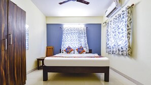A bedroom with a bed, a wardrobe, a ceiling fan, and an air conditioning unit. - Via Tasty Buds - 300m From Calangute Beach (Baga)