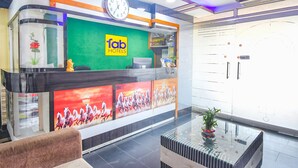A hotel reception desk with a clock, a green wall, and a sign that reads "Tab Hotels". - Fabhotel Golden Horizon (Ranchi)