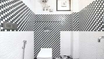 Un baño con piso de baldosas a cuadros, un inodoro, una ducha y una cámara de seguridad.