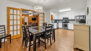 Une cuisine moderne avec des meubles blancs, un four à micro-ondes, un four traditionnel et un réfrigérateur.