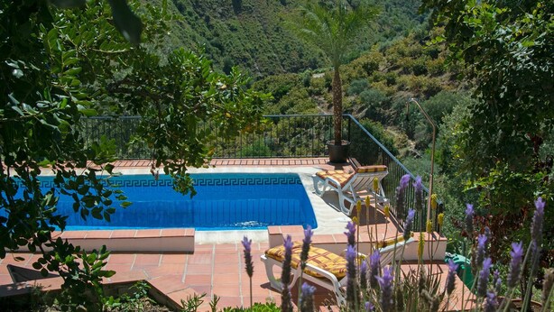 Ein Swimmingpool mit Blick auf eine gebirgige Landschaft.