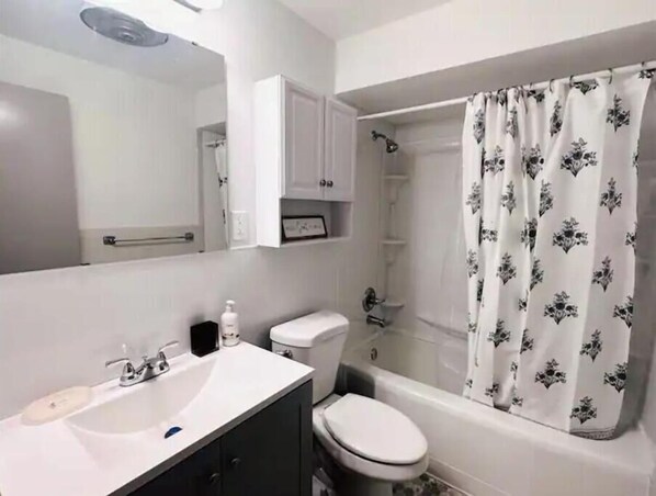 A bathroom with a white sink, toilet, and bathtub.