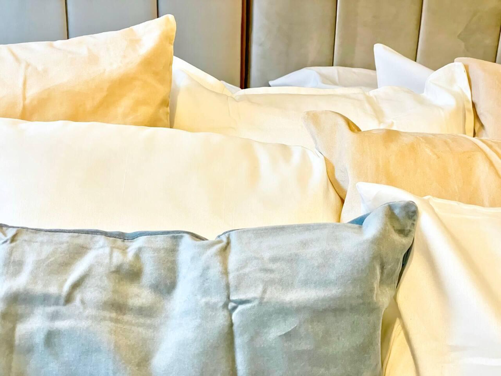 A bed with multiple pillows in a hotel room.
