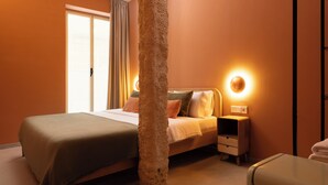 A hotel room with a large bed, a nightstand, a wall-mounted light, and a window with curtains. - The Loft House Madrid (Madrid)
