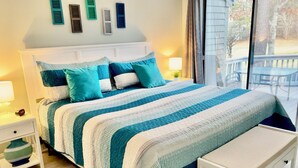 A neatly made bed with a striped blanket, a bedside table with a lamp, a small rug, and a bench. -   EXPLORE NEW SEABURY from our 2/2 Townhome - views + beach+ pool+ fireplace.  (Mashpee)