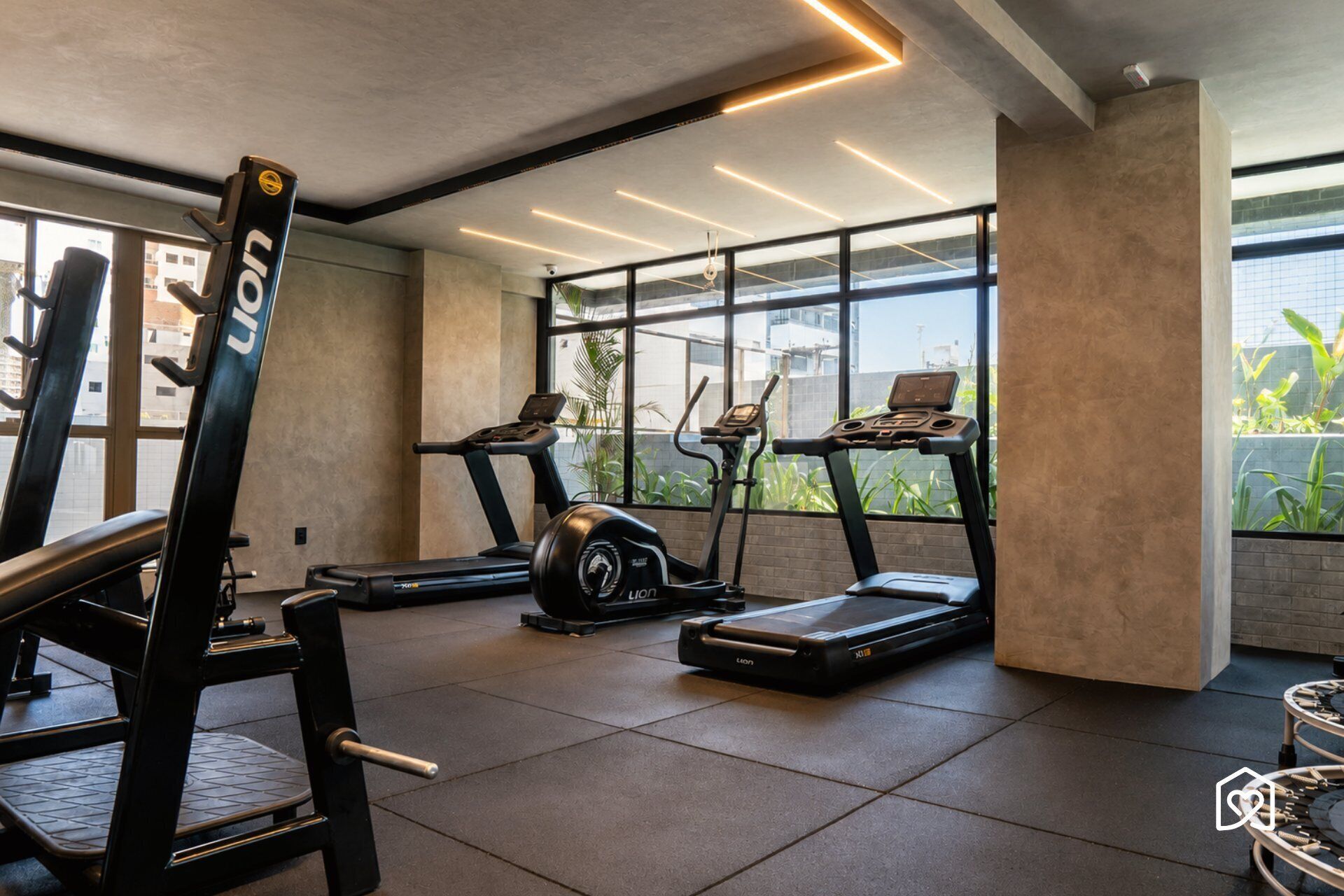 A gym with treadmills, a weight bench, and a rowing machine.