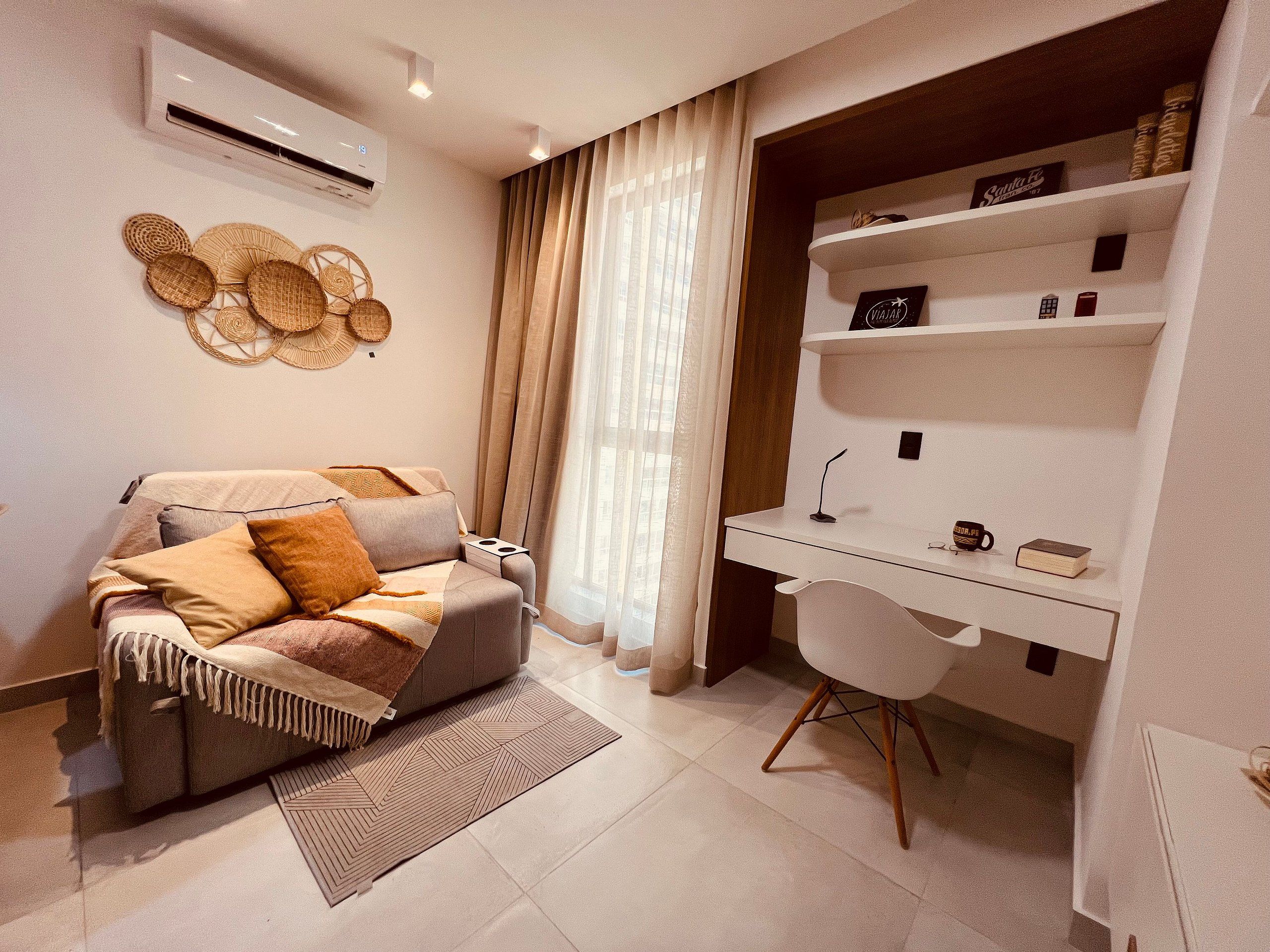 Quarto moderno com sofá, escrivaninha e uma cadeira.