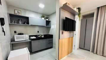 A modern kitchen with a microwave, coffee maker, and cabinets.