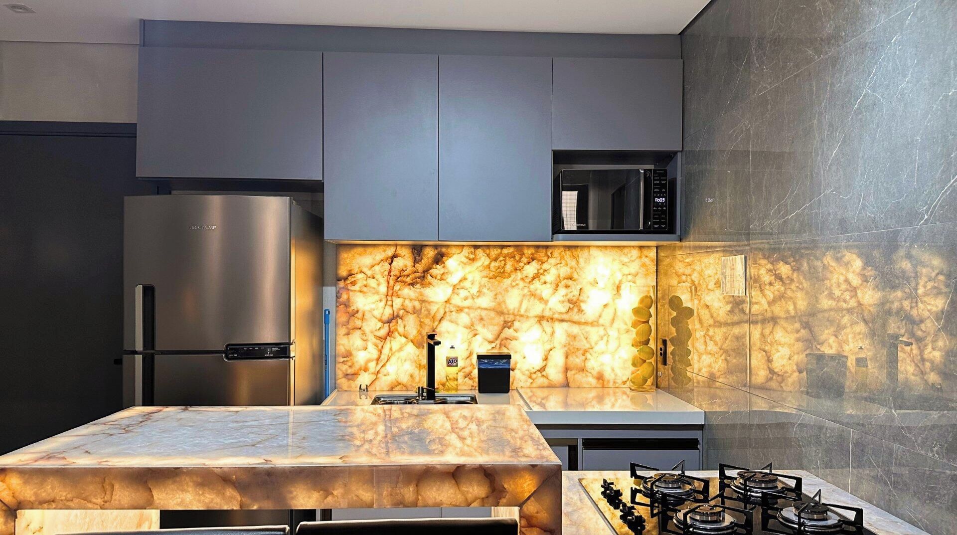 A modern kitchen with a marble countertop, stainless steel appliances, and a built-in microwave.