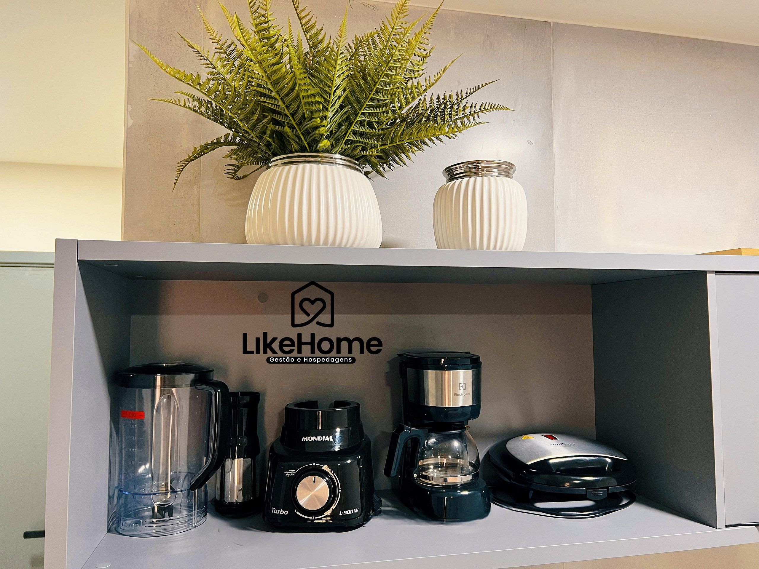 A kitchen area with a coffee maker, a blender, and a scale on the counter.