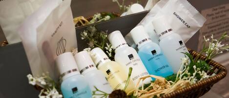 Un panier contenant divers produits de soins pour la peau, notamment une lotion pour le corps, un gel douche et un bonnet de douche.