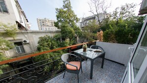 Un balcón con suelo estampado, una mesa y una silla.