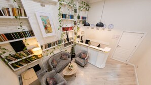 Una sala de estar moderna con un conjunto de sofá, una mesa de centro y una estantería llena de libros.