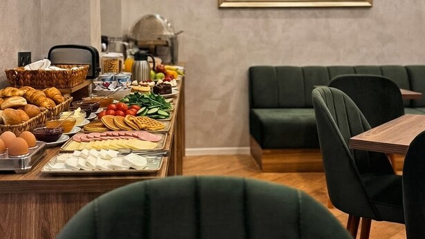 Un bufé de desayuno con diversos alimentos y un cuadro de un cielo nocturno en la pared.