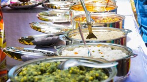 Un bufé con diversos platos, incluyendo arroz, verduras y curry.