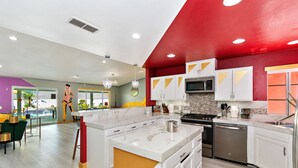 A modern kitchen with white cabinets, a stainless steel dishwasher, and a microwave. - Rock N Royalty: Pool, Spa, Fire Pit, Pool Table! (Bermuda Dunes)