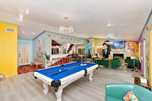 A pool table in a room with a bar and seating area, a television, and a mural. - Rock N Royalty: Pool, Spa, Fire Pit, Pool Table! (Bermuda Dunes)