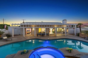 Una casa moderna con piscina, mobiliario exterior y zona de patio.