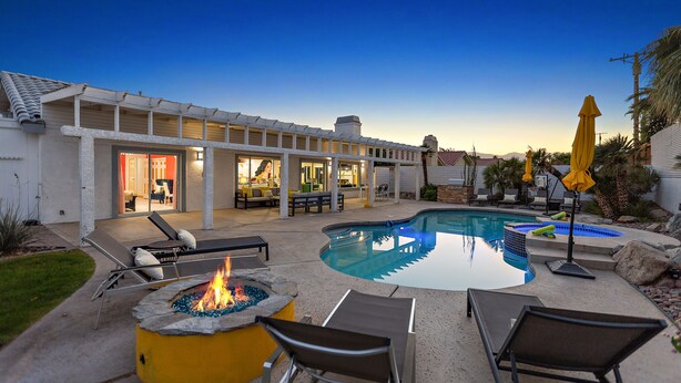 A pool area with lounge chairs, a fire pit, and a hot tub. - Rock N Royalty: Pool, Spa, Fire Pit, Pool Table! (Bermuda Dunes)