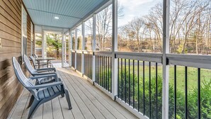 A covered porch with wooden railings and a table with chairs. - Spacious Home Close to Beaches! 3BR, Dog & Family Friendly, 30 Mins to Portland (Biddeford)