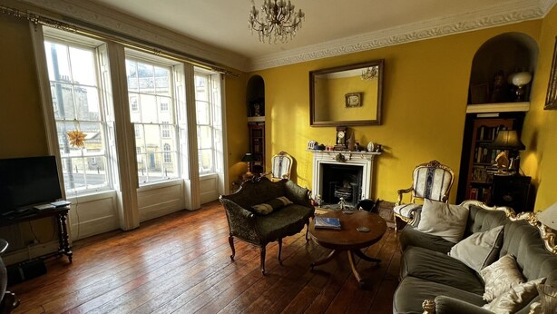 Une pièce avec une cheminée, deux fauteuils, une table basse et un téléviseur.