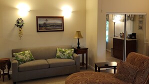 A living room with a sofa, armchair, lamp, and ceiling fan. - Large studio-prvt entry-prvt bathroom-option A/C (Papaikou)