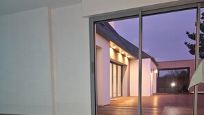 A modern house with a swimming pool, large glass doors, and a well-lit interior. - Villa with indoor pool 5 minutes walk from the beach (Plouguerneau)