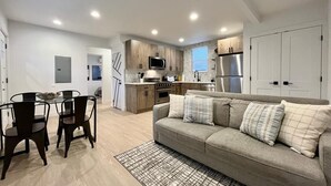 Un appartement moderne comprenant une cuisine, un coin repas et un salon.