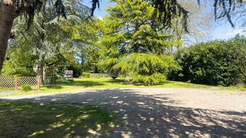 En välskött park med en grusgång, en lekplats och olika sorters träd.