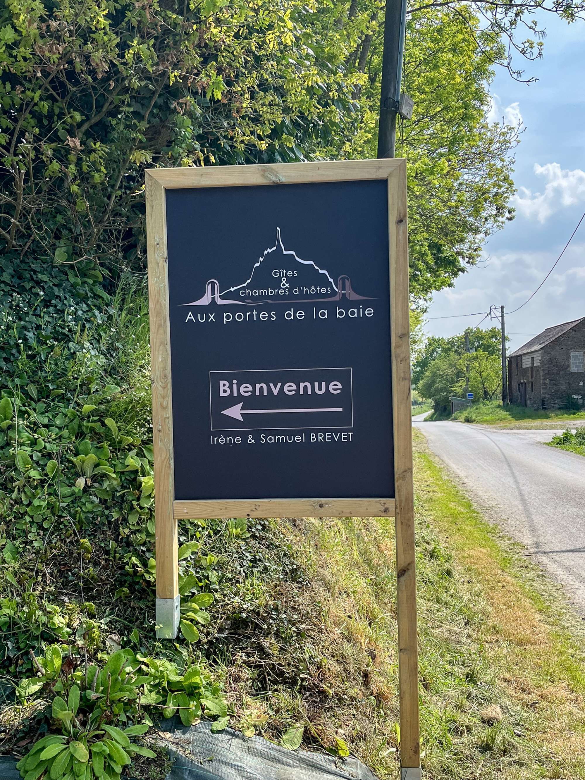A welcome sign for 'Irene & Samuel Brevet' with a mountain silhouette and a directional arrow.