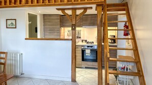 Eine moderne Küche mit Holzelementen, einer Treppe und Blick zum Wohnbereich.