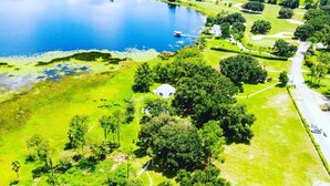 Vista aérea de un campo de golf con un lago grande, un club de campo y zonas verdes cuidadas.