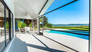 A balcony with a pool, clear sky, and a view of the water. - Swiss 06 - Lake Sumner (Clermont)