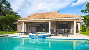 A poolside area with a tiled deck, lounge chairs, and a covered patio. - Swiss 101 - Lake Olsen (Clermont)