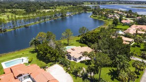 A residential area with a large lake, houses with red-tiled roofs, and a swimming pool. - Swiss 23 - Lake Stephanie (Clermont)