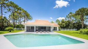 A modern house with a swimming pool, surrounded by a white fence and lush greenery. - Swiss 31 - Golf Course (Clermont)