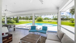 A covered patio with a pool, outdoor furniture, and a ceiling fan. - Swiss 31 - Golf Course (Clermont)