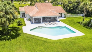 A modern house with a swimming pool, a covered patio, and a well-maintained lawn. - Swiss 31 - Golf Course (Clermont)