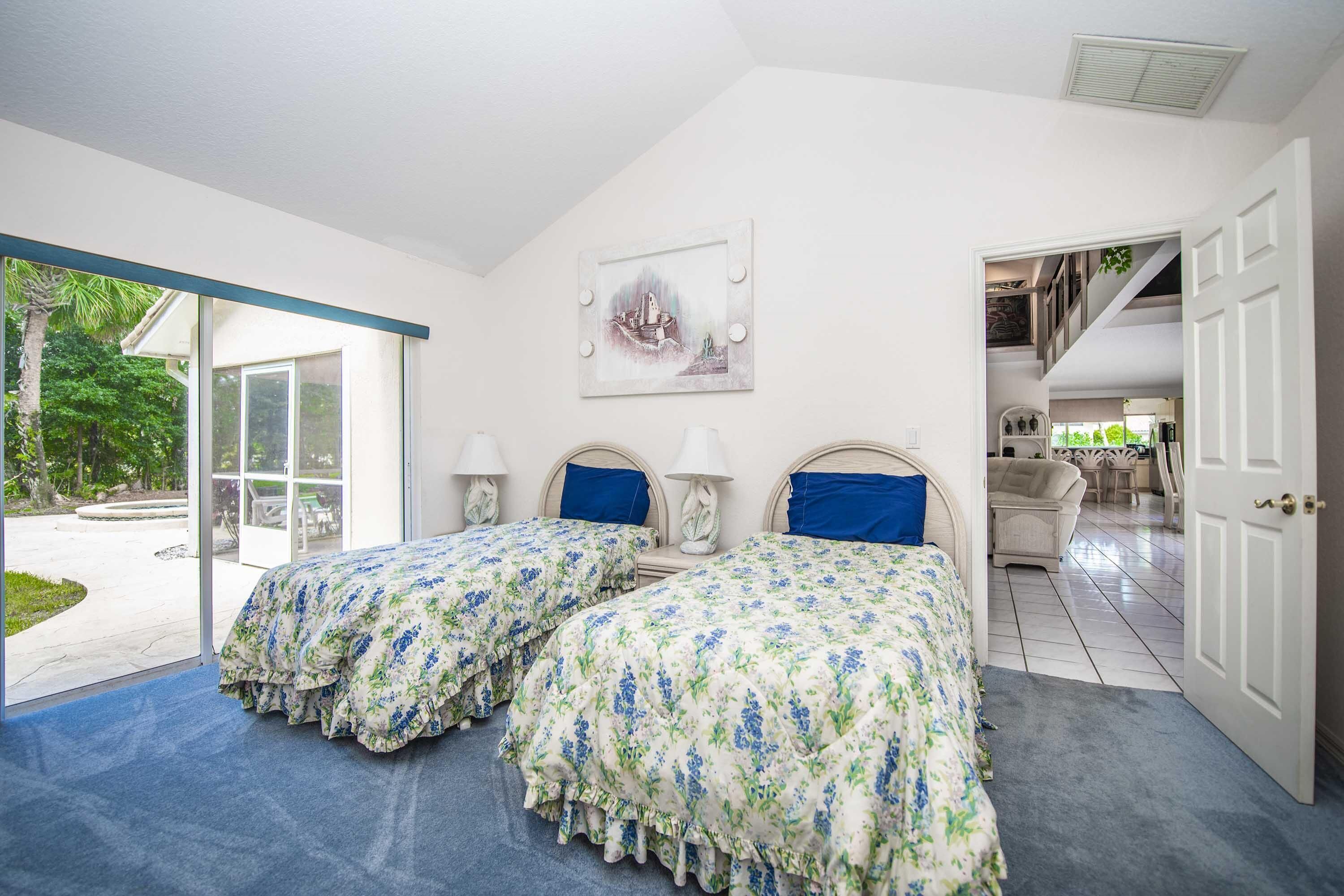 Une chambre avec deux lits, une grande fenêtre et une vue sur l’extérieur.