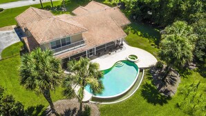 A house with a swimming pool, surrounded by lush greenery and palm trees. - Swiss 41 - Golf Course (Clermont)