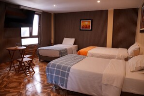 A hotel room with two single beds, a wooden chair, a small table, and a window. - Posada Miraflores (Lima)
