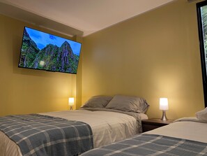 Habitación cuádruple estándar, dormitorio mixto, baño privado, vistas al patio | Mobiliario individual y espacio para trabajar con un portátil