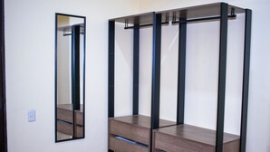 A room with a wooden wardrobe and a mirror on the wall.