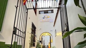 An entrance with a tiled floor, metal gates, and flags.