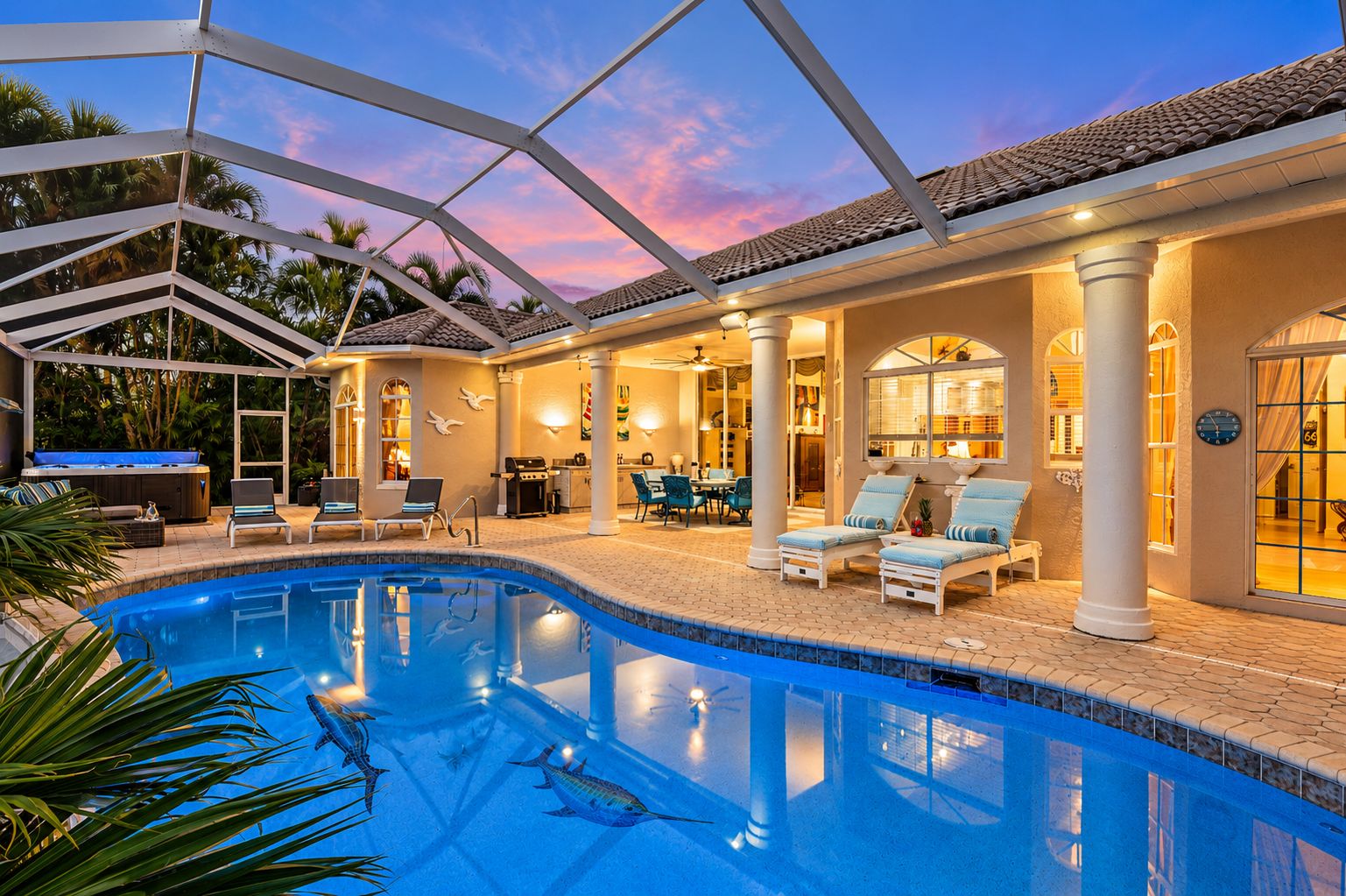 A pool area with lounge chairs, a hot tub, and a covered patio with a dining area.
