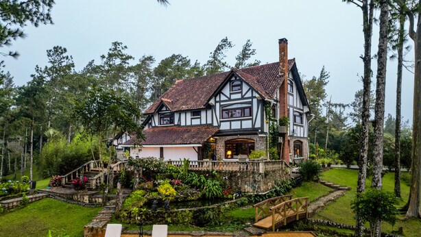 A large house with a wooden deck, a hot tub, and a garden. - Tudor Mountain Retreat (Panamá)
