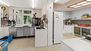 Una cocina moderna con armarios blancos, horno integrado y refrigerador.