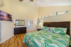 A bedroom with a bed, dresser, and a painting on the wall. - Gulf View * Sunsets * Boat parking * King Bed * Walk to Downtown (Cedar Key)