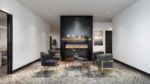 Un interior moderno con chimenea, dos sillones, una mesa de centro redonda y una alfombra estampada.